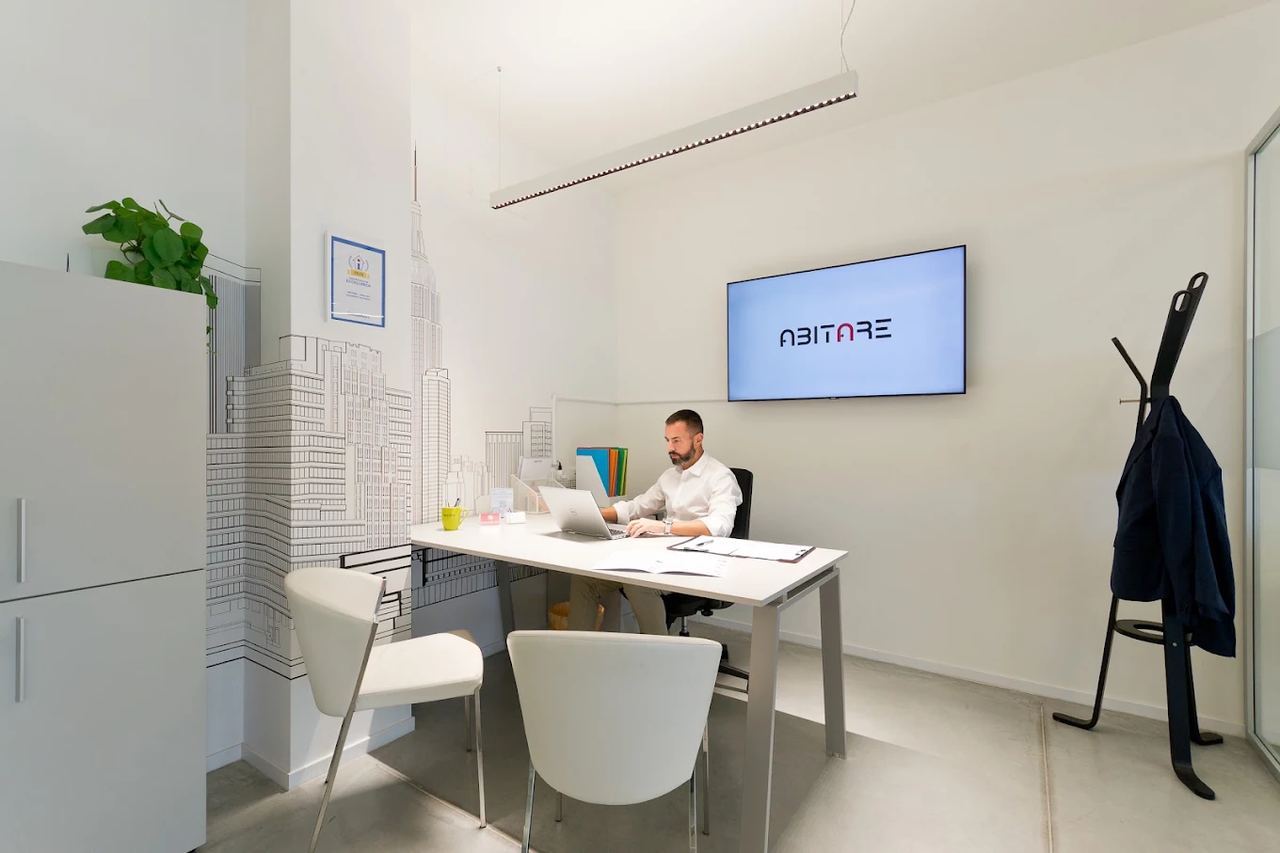 Un consulente al lavoro alla scrivania sotto lo schermo con il logo